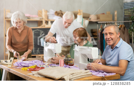Elderly man enjoying sewing and social time in class Elderly man enjoying sewing and social time in class 128838285