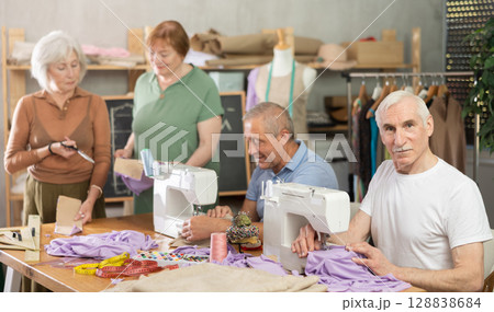 Elderly participants in sewing coterie learn sewing, communicate and talking, sewing, cut fabric by scissors 128838684