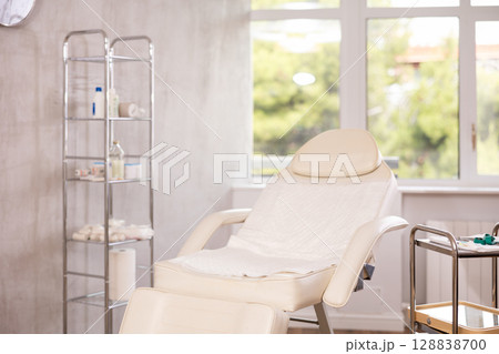Interior of aesthetic cosmetolody clinic with chair for patient and equipment for cosmetic procedures Interior of aesthetic cosmetolody clinic with chair for patient and equipment for cosmetic procedures 128838700