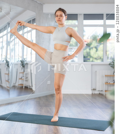 Young woman practicing yoga asanas in studio 128838884