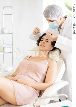 Woman getting procedure of injection contouring and for facial correction in clinic Woman getting procedure of injection contouring and for facial correction in clinic 128838957