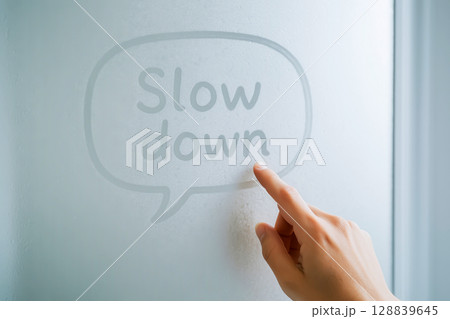 Finger Drawing Slow Down On Foggy Glass Window In Soft Light. Concept For Mindful Living, Stress Relief, Mental Health Pause, Slow Lifestyle Aesthetics, And Calming Everyday Moments 128839645