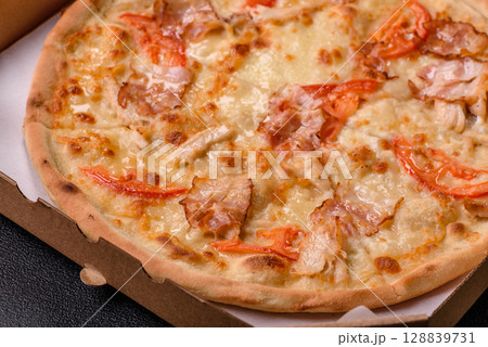 Italian pizza with chicken and bacon, cheese, tomatoes and sauce Italian pizza with chicken and bacon, cheese, tomatoes and sauce 128839731