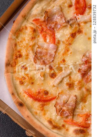 Italian pizza with chicken and bacon, cheese, tomatoes and sauce 128839732