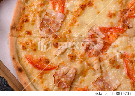 Italian pizza with chicken and bacon, cheese, tomatoes and sauce 128839733