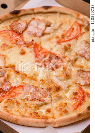 Italian pizza with chicken and bacon, cheese, tomatoes and sauce 128839738