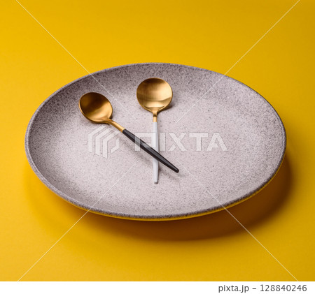 Empty plate with devices in the form of clock hands as a conceptual background for lunch time 128840246