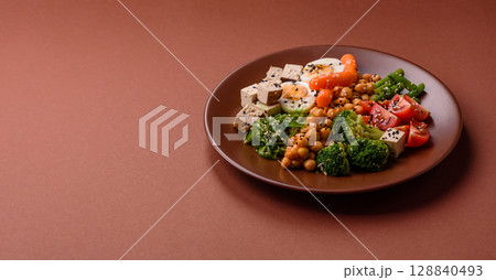 Vegan salad, bowls with chickpeas, broccoli, tomatoes, tofu cheese and boiled eggs 128840493