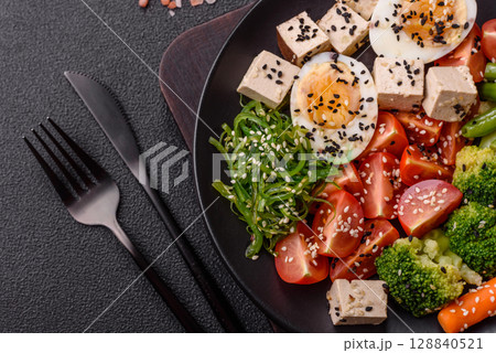 Vegan salad, bowls with chickpeas, broccoli, tomatoes, tofu cheese and boiled eggs 128840521