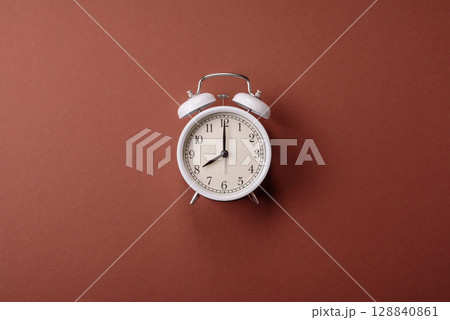Vintage alarm clock on brown surface as a conceptual background for deadlines for tasks Vintage alarm clock on brown surface as a conceptual background for deadlines for tasks 128840861