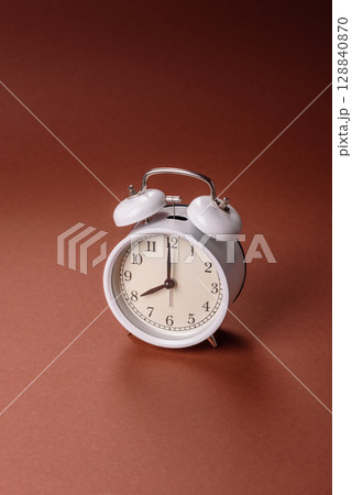 Vintage alarm clock on brown surface as a conceptual background for deadlines for tasks Vintage alarm clock on brown surface as a conceptual background for deadlines for tasks 128840870