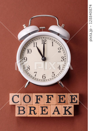 Alarm clock and coffee break lettering as a conceptual backdrop for a work break or meeting 128840874