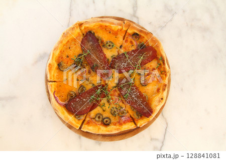 assorted pizza with different fillings: salami, tomatoes, mushrooms, bacon, sun-dried tomatoes 128841081