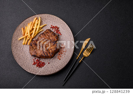 Meat, steak, beef tenderloin cooked on grill. Juicy steak as a food background 128841239