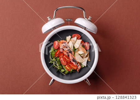 Salad with chicken, tomatoes and eggs with seeds and grains. Concept time to eat dinner 128841323