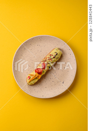 French food, dessert eclair with chocolate filling. Eclair as a background 128841443