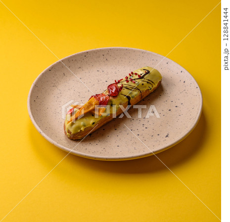 French food, dessert eclair with chocolate filling. Eclair as a background French food, dessert eclair with chocolate filling. Eclair as a background 128841444