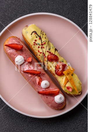 French food, dessert eclair with chocolate filling. Eclair as a background French food, dessert eclair with chocolate filling. Eclair as a background 128841479