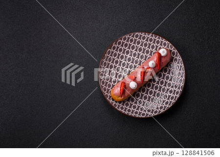 French food, dessert eclair with chocolate filling. Eclair as a background 128841506