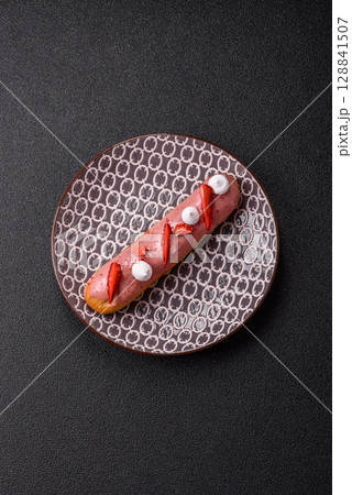 French food, dessert eclair with chocolate filling. Eclair as a background 128841507