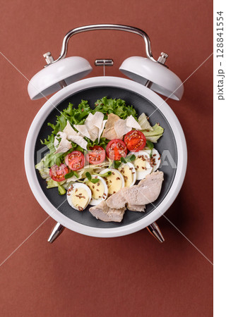 Salad with chicken, tomatoes and eggs with seeds and grains. Concept time to eat dinner 128841554