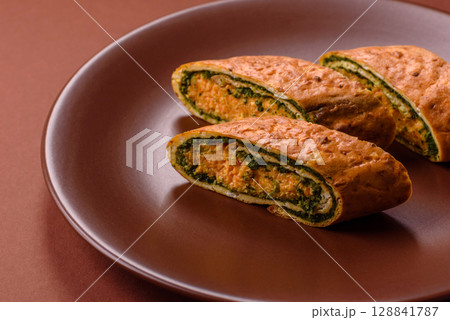 Roll of omelette, spinach, cheese and minced meat 128841787