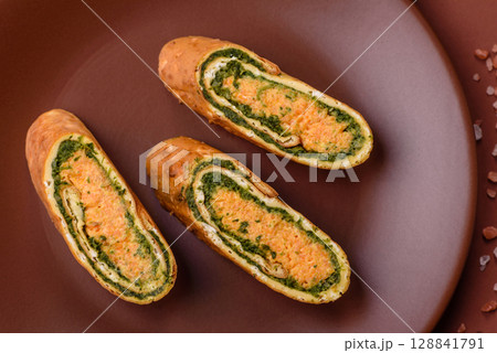 Roll of omelette, spinach, cheese and minced meat 128841791