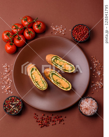 Roll of omelette, spinach, cheese and minced meat Roll of omelette, spinach, cheese and minced meat 128841795