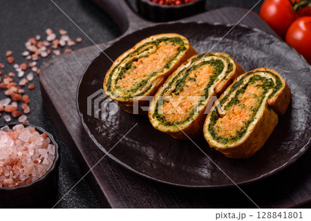 Roll of omelette, spinach, cheese and minced meat 128841801