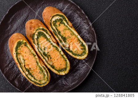 Roll of omelette, spinach, cheese and minced meat 128841805