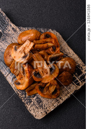 Food, baked mushrooms champignon slices with sauce and spices 128841886