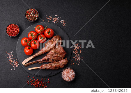 Juicy meat on the bone or rack of lamb. Grilled veal with salt, spices and herbs Juicy meat on the bone or rack of lamb. Grilled veal with salt, spices and herbs 128842025