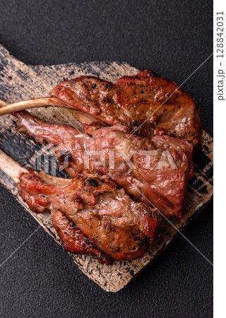 Juicy meat on the bone or rack of lamb. Grilled veal with salt, spices and herbs Juicy meat on the bone or rack of lamb. Grilled veal with salt, spices and herbs 128842031