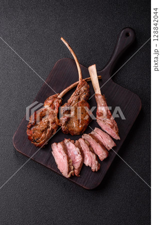 Juicy meat on the bone or rack of lamb. Grilled veal with salt, spices and herbs Juicy meat on the bone or rack of lamb. Grilled veal with salt, spices and herbs 128842044