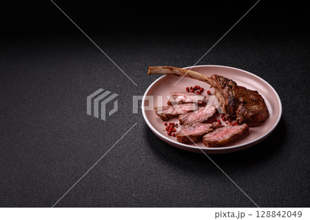 Juicy meat on the bone or rack of lamb. Grilled veal with salt, spices and herbs Juicy meat on the bone or rack of lamb. Grilled veal with salt, spices and herbs 128842049