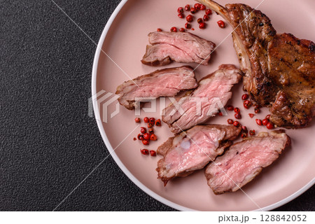 Juicy meat on the bone or rack of lamb. Grilled veal with salt, spices and herbs Juicy meat on the bone or rack of lamb. Grilled veal with salt, spices and herbs 128842052