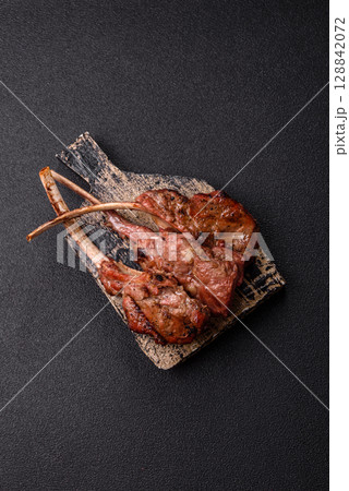 Juicy meat on the bone or rack of lamb. Grilled veal with salt, spices and herbs 128842072