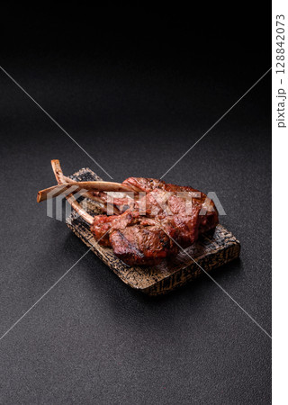 Juicy meat on the bone or rack of lamb. Grilled veal with salt, spices and herbs Juicy meat on the bone or rack of lamb. Grilled veal with salt, spices and herbs 128842073