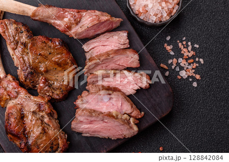 Juicy meat on the bone or rack of lamb. Grilled veal with salt, spices and herbs 128842084
