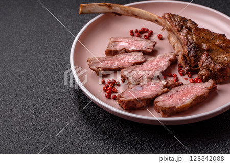 Juicy meat on the bone or rack of lamb. Grilled veal with salt, spices and herbs Juicy meat on the bone or rack of lamb. Grilled veal with salt, spices and herbs 128842088