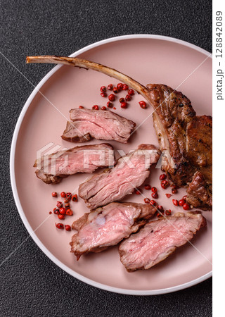 Juicy meat on the bone or rack of lamb. Grilled veal with salt, spices and herbs 128842089