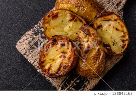 Food, potatoes cut in halves or slices grilled. Cooked baked potatoes 128842168