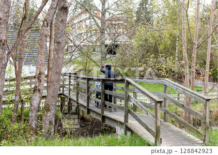 young Woman with Stroller Crossing Wooden Bridge on Rainy Spring Day young Woman with Stroller Crossing Wooden Bridge on Rainy Spring Day 128842923