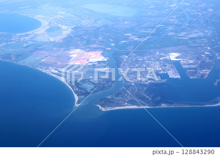 Aerial Coastal View with Rivers, Lands, and Ocean Surrounding Industrial Areas 128843290