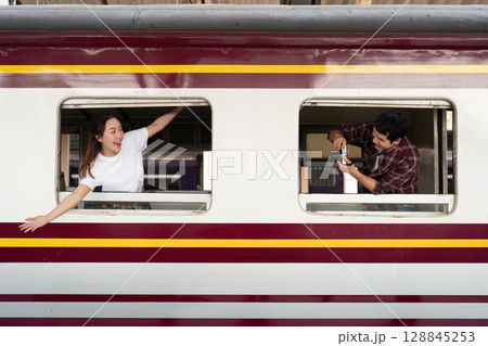 Couple enjoying train travel, capturing moments together Couple enjoying train travel, capturing moments together 128845253