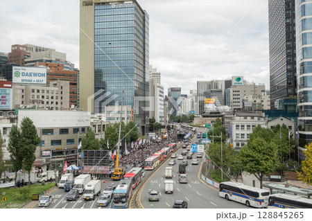【韓国】ソウル駅前の歩道橋から望むデモ集会と幹線道を行き交う車やオフィスビルのある風景 128845265