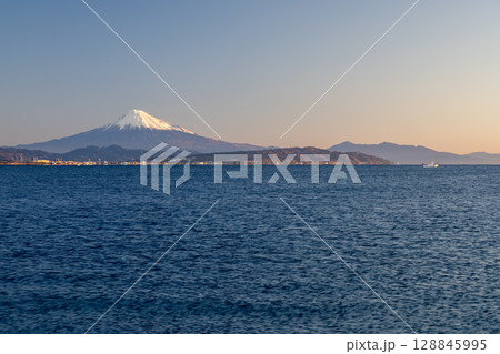 焼津の石津浜から望む富士山と日本平・愛鷹山、朝日に浮かぶ漁船 128845995