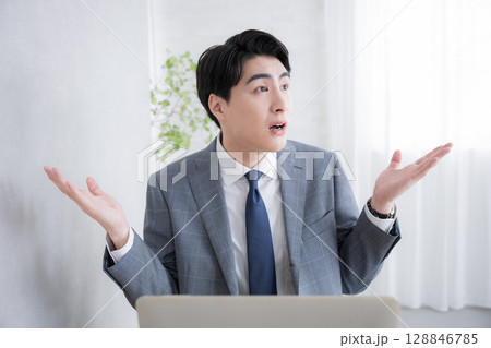 パソコンの前で仕事のお手上げポーズ　もうやってられない！ 128846785