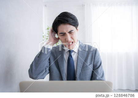 パソコンの前で頭を抱える　もう仕事のストレスすごすぎる… 128846786