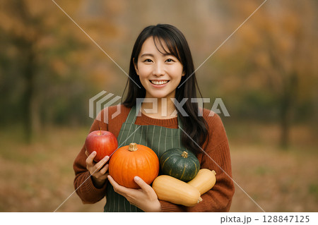 食欲の秋イメージ　旬の食材を抱える笑顔の女性 128847125